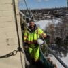 S426 S876 Man working on the side of a building wearing Work King 5 in 1 Saftey jacket and insulated safety overall